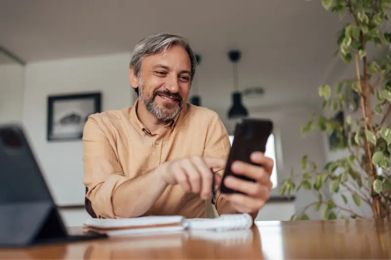 Man using the Fourchealth app on her smartphone to book a chronic condition management appointment