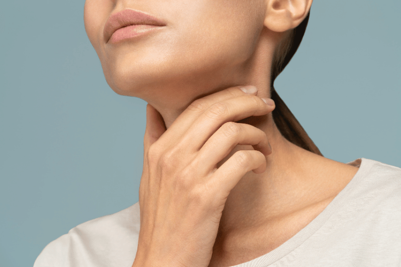 Woman experiencing possible thyroid symptoms affecting the neck